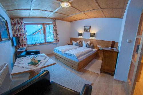 a large bedroom with a bed and a table at Pension Alwin in Lech am Arlberg