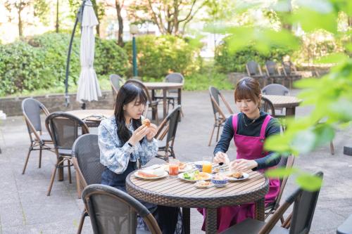 two girls sitting at a table eating food at Hotel ARU KSP in Kawasaki