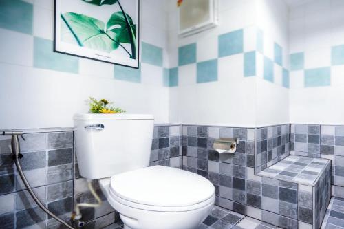 a bathroom with a toilet and a picture on the wall at Hua Hin First-Hin Nam in Hua Hin