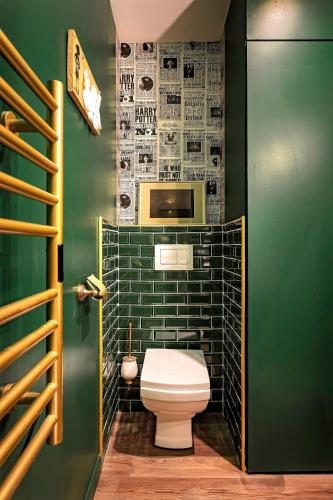 La salle de bains est pourvue de toilettes et d'un mur vert. dans l'établissement Le Repaire des Sorciers - T2 Magique avec Clim, à Toulouse