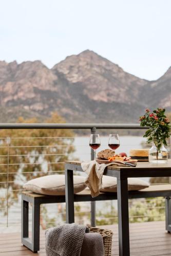 a table with two glasses of wine on a balcony at The Moorings at Freycinet Coles Bay in Coles Bay