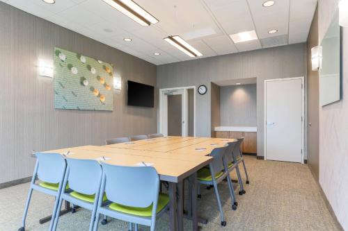 a conference room with a wooden table and blue chairs at SpringHill Suites by Marriott Tallahassee North in Tallahassee