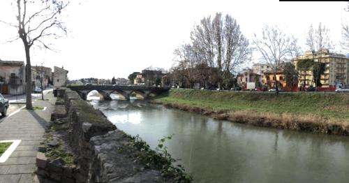 a river with a bridge in a city at Hotel Le Mura in Foligno