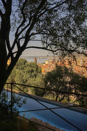 a view of a city from behind a tree at Hôtel du Couvent, a Luxury Collection Hotel, Nice in Nice