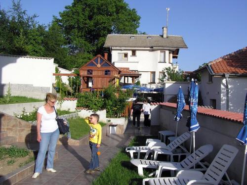 a woman and a child standing next to a house at Hotel Aleksievata Kashta in Gurgulyat