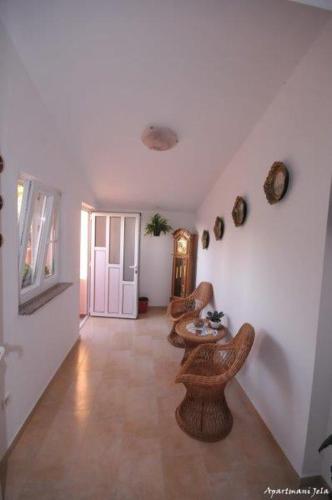 a hallway with chairs and a table in a room at Apartments Jela in Metajna