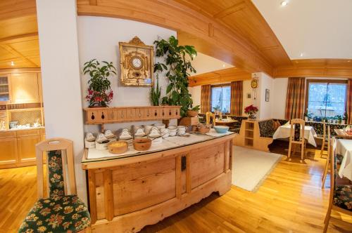a large room with a large wooden island with cups on it at Pension Alwin in Lech am Arlberg