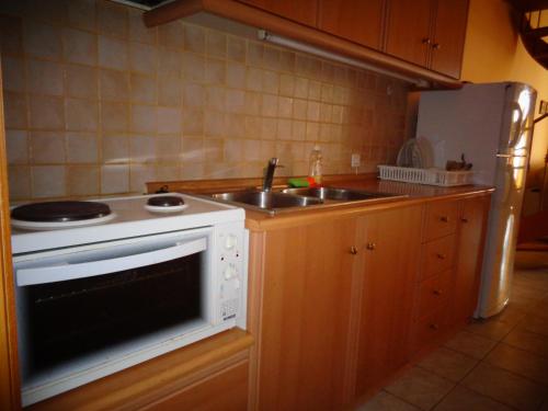 a kitchen with a white stove and a sink at Bell Air Hotel in Alexandroupoli
