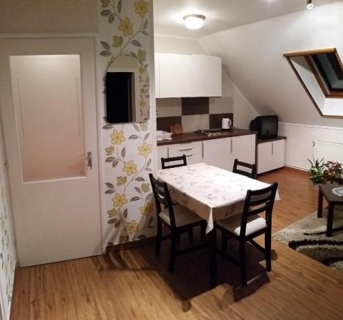 a kitchen and dining room with a table and chairs at FaDóra Apartman in Tihany