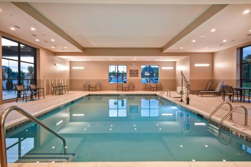 a pool in a hotel with tables and chairs at Residence Inn by Marriott Cincinnati Northeast/Mason in Mason