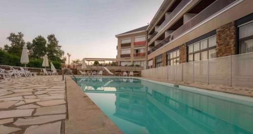 une piscine devant un immeuble dans l'établissement authentic by balladins – Rodez / Le Ségala, à Baraqueville
