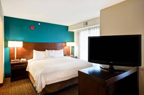 a hotel room with a bed and a flat screen tv at Residence Inn by Marriott Dayton Beavercreek in Beavercreek