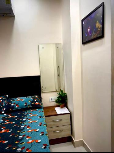 a bedroom with a bed and a dresser with a mirror at Chic Studio To Stay in South Delhi in New Delhi