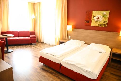 a hotel room with a bed and a couch at Hotel Marienthal Garni in Hamburg