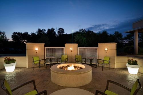 a patio with a fire pit with chairs and tables at SpringHill Suites Ewing Township Princeton South in Ewing