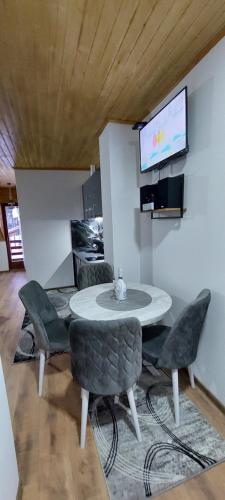 a dining room with a table and chairs and a tv at Vila MINA LUX in Kaludjerske Bare