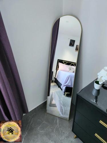 a mirror in a room with a bed and a dresser at Simpson's Little Gem in Kingston