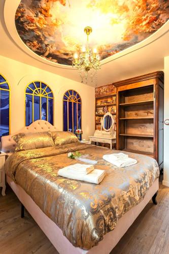 - une chambre dotée d'un grand lit et d'une peinture au plafond dans l'établissement Le Voyage Enchanté - T3 Féérique & équipé, à Toulouse