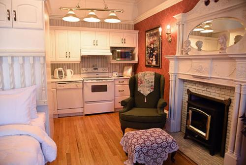 a bedroom with a fireplace and a bed and a chair at Noble Waterfront Suites in Brockville