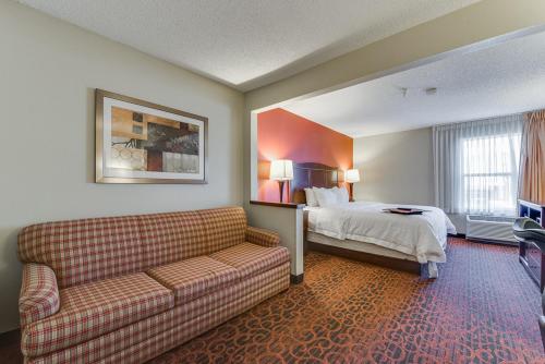 a hotel room with a couch and a bed at Baymont by Wyndham Oklahoma City/Quail Springs in Oklahoma City
