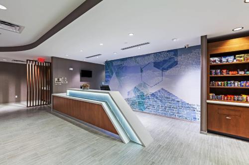 a waiting area in a hospital with a large screen at SpringHill Suites by Marriott Tulsa at Tulsa Hills in Tulsa