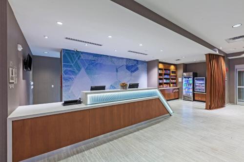 an office lobby with a reception desk and a large screen at SpringHill Suites by Marriott Tulsa at Tulsa Hills in Tulsa