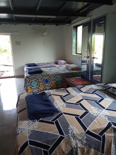 two beds in a room with a pattern on the floor at 5 Kesar Baug Resort in Ānjarle