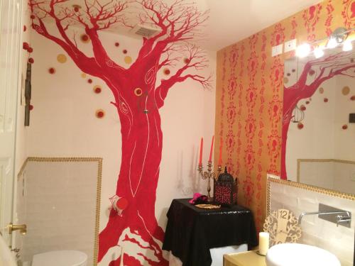 a bathroom with a tree painted on the wall at La Stagione dell'Arte in Camaiore