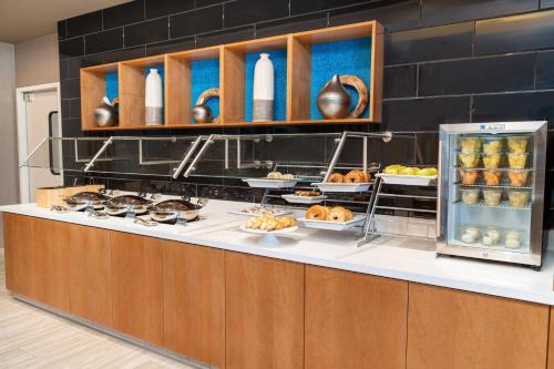 a kitchen with a counter with food on it at SpringHill Suites by Marriott Irvine Lake Forest in Lake Forest