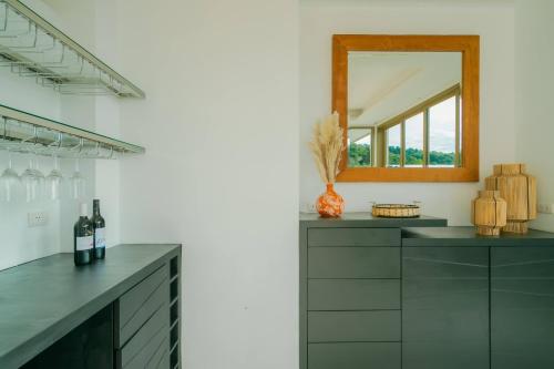 a kitchen with a mirror and a counter with wine bottles at Seaview Villa Near Naithon Beach Phuket in Nai Thon Beach