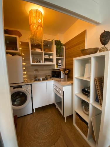 une cuisine avec un évier et une machine à laver dans l'établissement Le studio Bohème, à Dinard