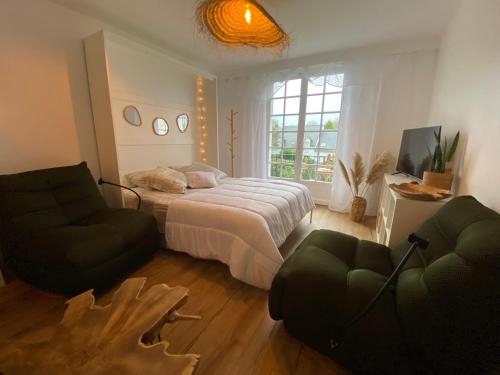 une chambre avec un lit, un canapé et une télévision dans l'établissement Le studio Bohème, à Dinard