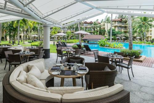 an outdoor restaurant with tables and chairs and a pool at Phuket Marriott Resort & Spa, Merlin Beach in Patong Beach