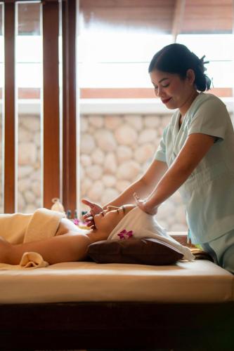 a woman is getting a massage from a girl at Phuket Marriott Resort & Spa, Merlin Beach in Patong Beach