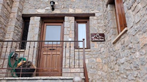 a stone building with a wooden door and a balcony at Alina's House in Arachova