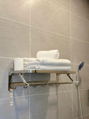 a towel rack with towels on it in a bathroom at Sunflower Garden Homestay Đà Lạt in Xuan An