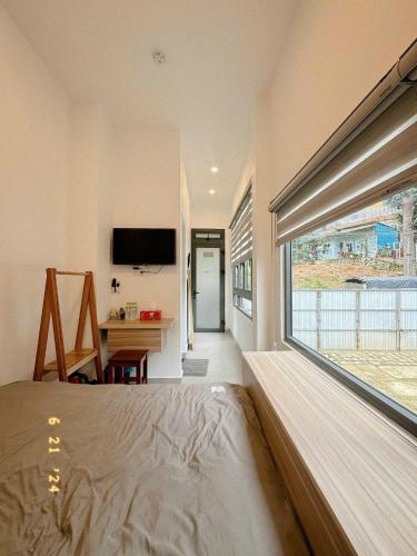 a bedroom with a bed and a large window at Sunflower Garden Homestay Đà Lạt in Xuan An