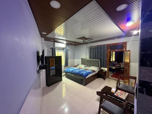 a bedroom with a bed and a desk in a room at Sadyal Hotel And Restaurant in Tīra Sujānpur