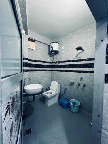 a bathroom with a toilet and a sink at Sadyal Hotel And Restaurant in Tīra Sujānpur