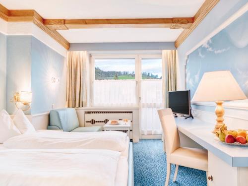 a hotel room with a bed and a desk with a computer at Genuss - und Vitalhotel Moisl in Abtenau