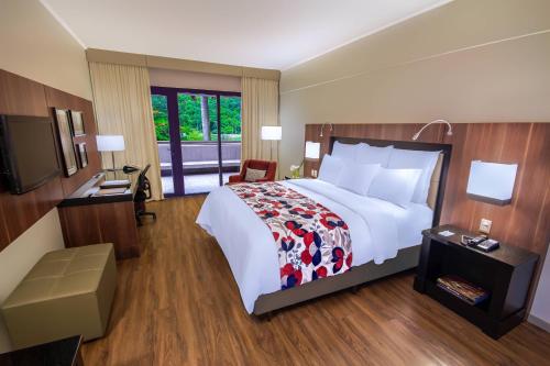 a hotel room with a large bed and a television at Marriott São Paulo Airport Hotel in Guarulhos