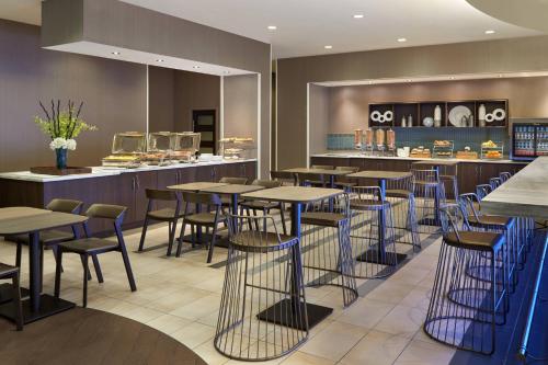 a restaurant with tables and chairs and a counter at SpringHill Suites by Marriott Toronto Vaughan in Vaughan