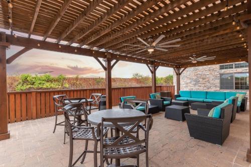 a patio with tables and chairs under a wooden pergola at SpringHill Suites by Marriott Waco Woodway in Woodway