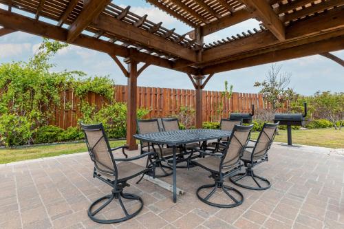 a patio table and chairs under a wooden pergola at SpringHill Suites by Marriott Waco Woodway in Woodway