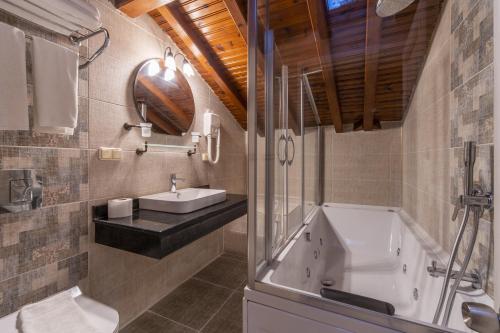 a bathroom with a sink and a bath tub at La Paloma Hotel in Antalya