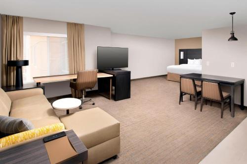 a hotel room with a couch and a bed at Residence Inn by Marriott Denver Airport/Convention Center in Denver