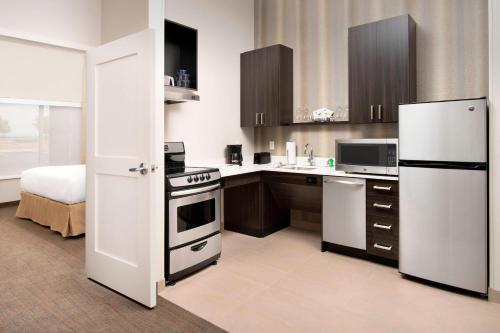 a kitchen with a white refrigerator and a stove at Residence Inn by Marriott Denver Airport/Convention Center in Denver