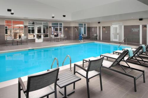 a large swimming pool with chairs and tables at Residence Inn by Marriott Denver Airport/Convention Center in Denver