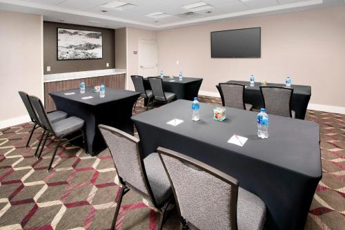 a conference room with tables and chairs and a screen at Residence Inn by Marriott Denver Airport/Convention Center in Denver