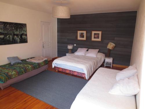 a bedroom with two beds and a rug at Gite Les Arrebourits 4 étoiles in Anères